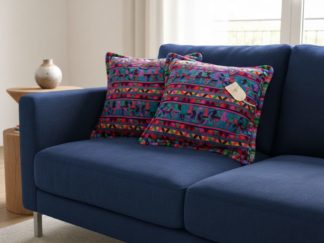 Coussin huipil birds sur sofa bleu - motif oiseau large mauves